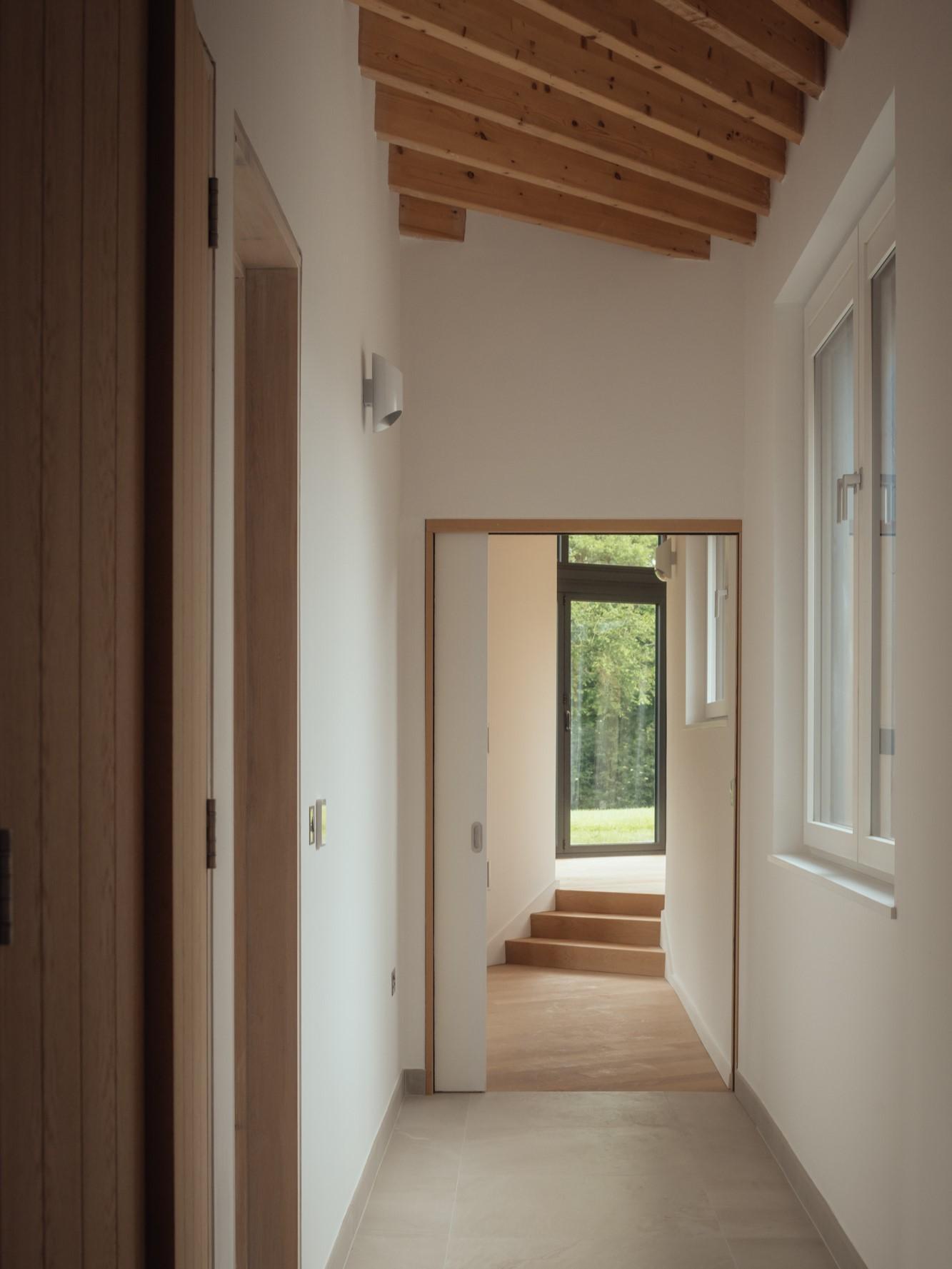 Contemporary hallway with exposed beams by Studio Bark