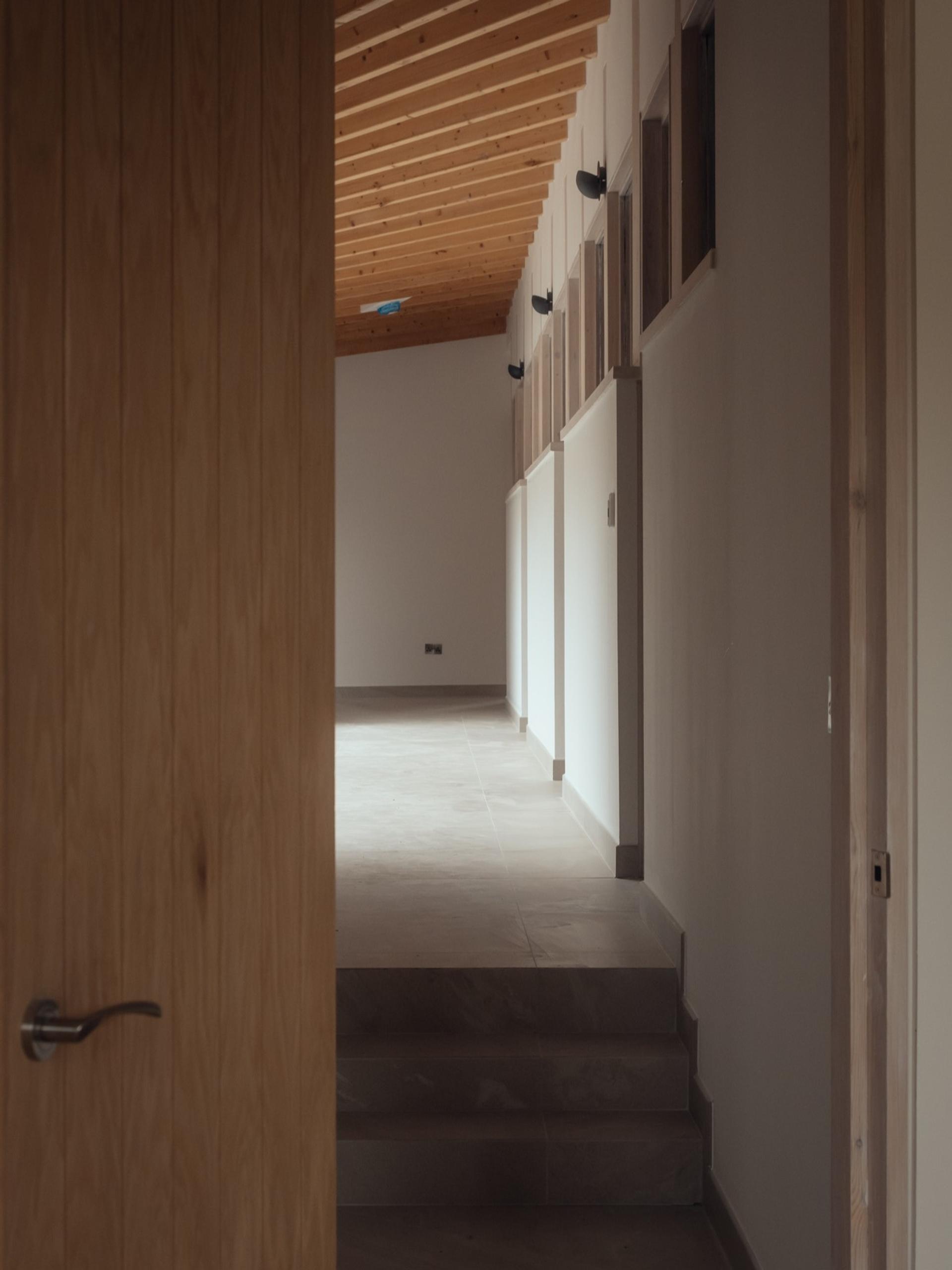 Contemporary hallway with exposed beams by Studio Bark