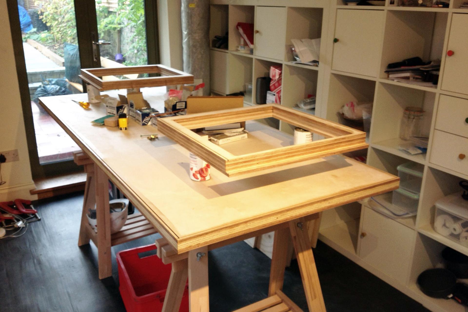 Window frames are laid on the table to be fit inside the pod