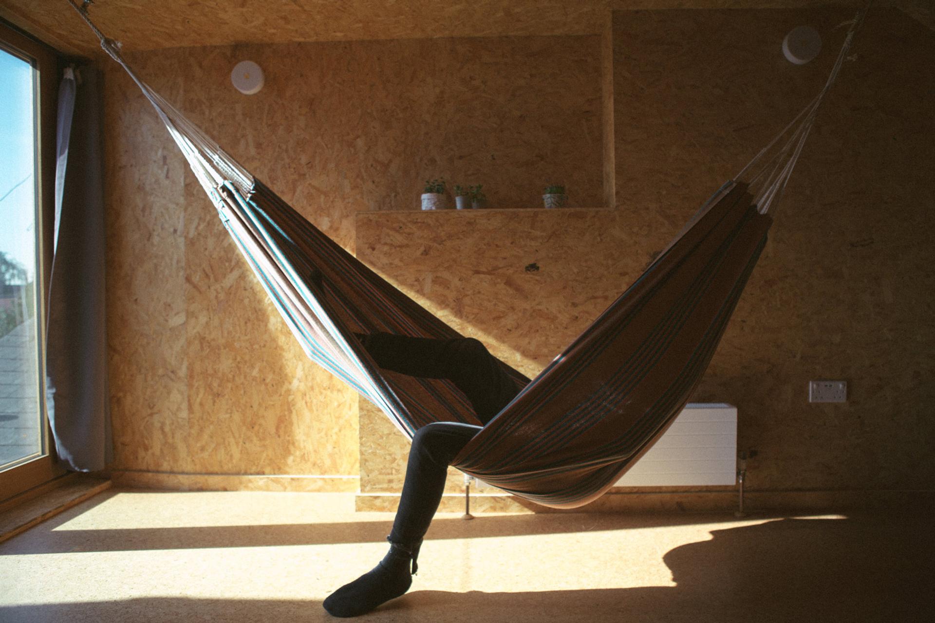 Person lounging in hammock in light-filled roof extension