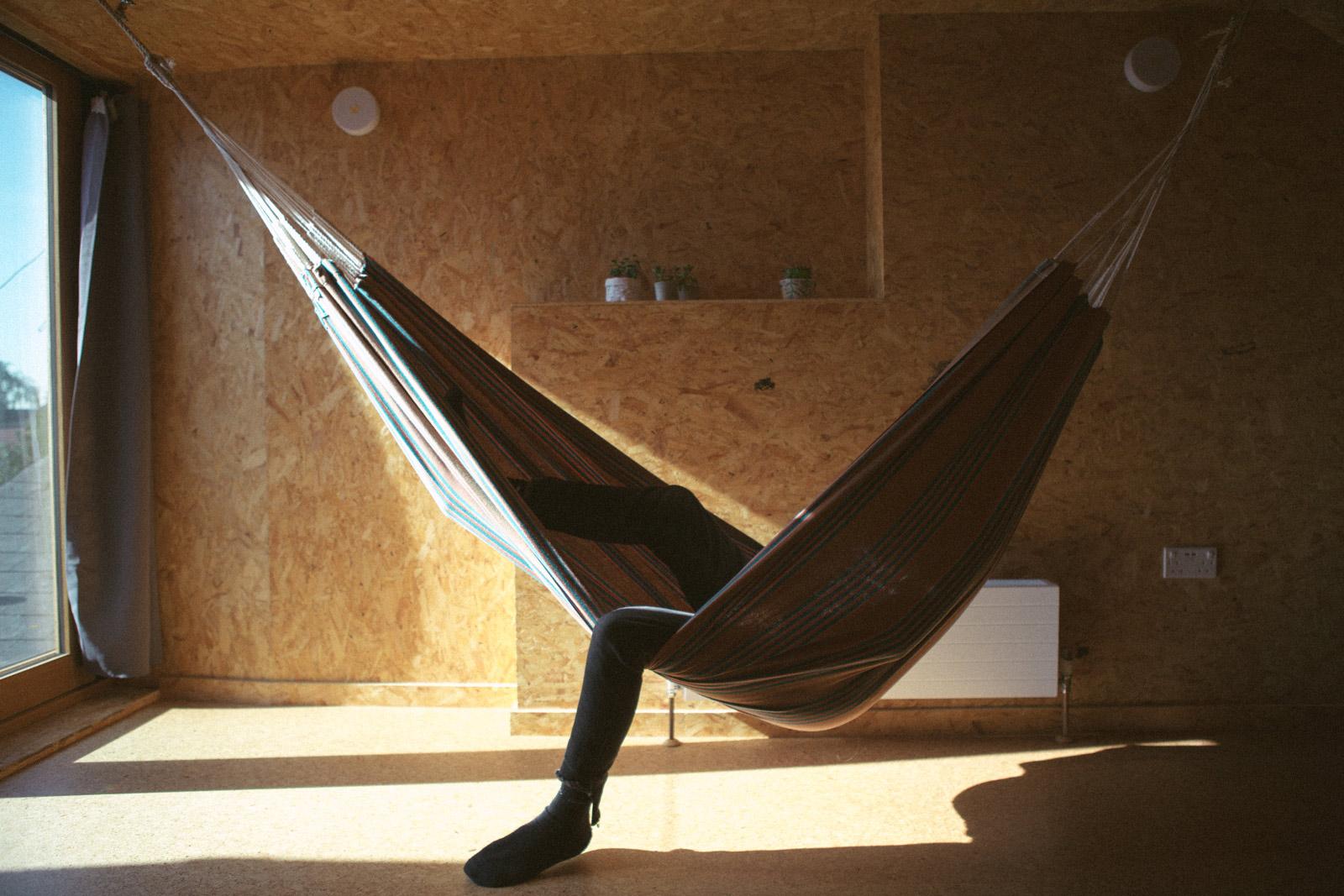 Person lounging in hammock in light-filled roof extension
