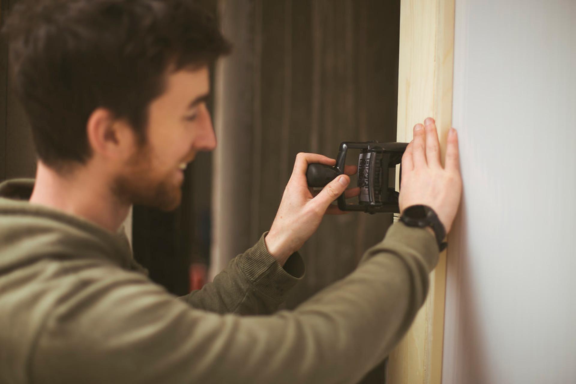 Man stamping doorframe with a Studio Bark stamp