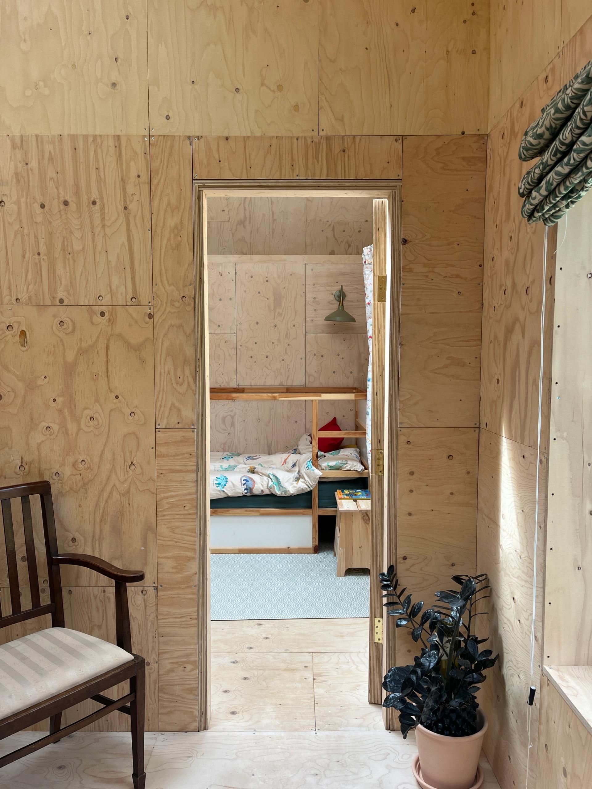 U-build modern timber extension with natural light, plant, and vintage chair