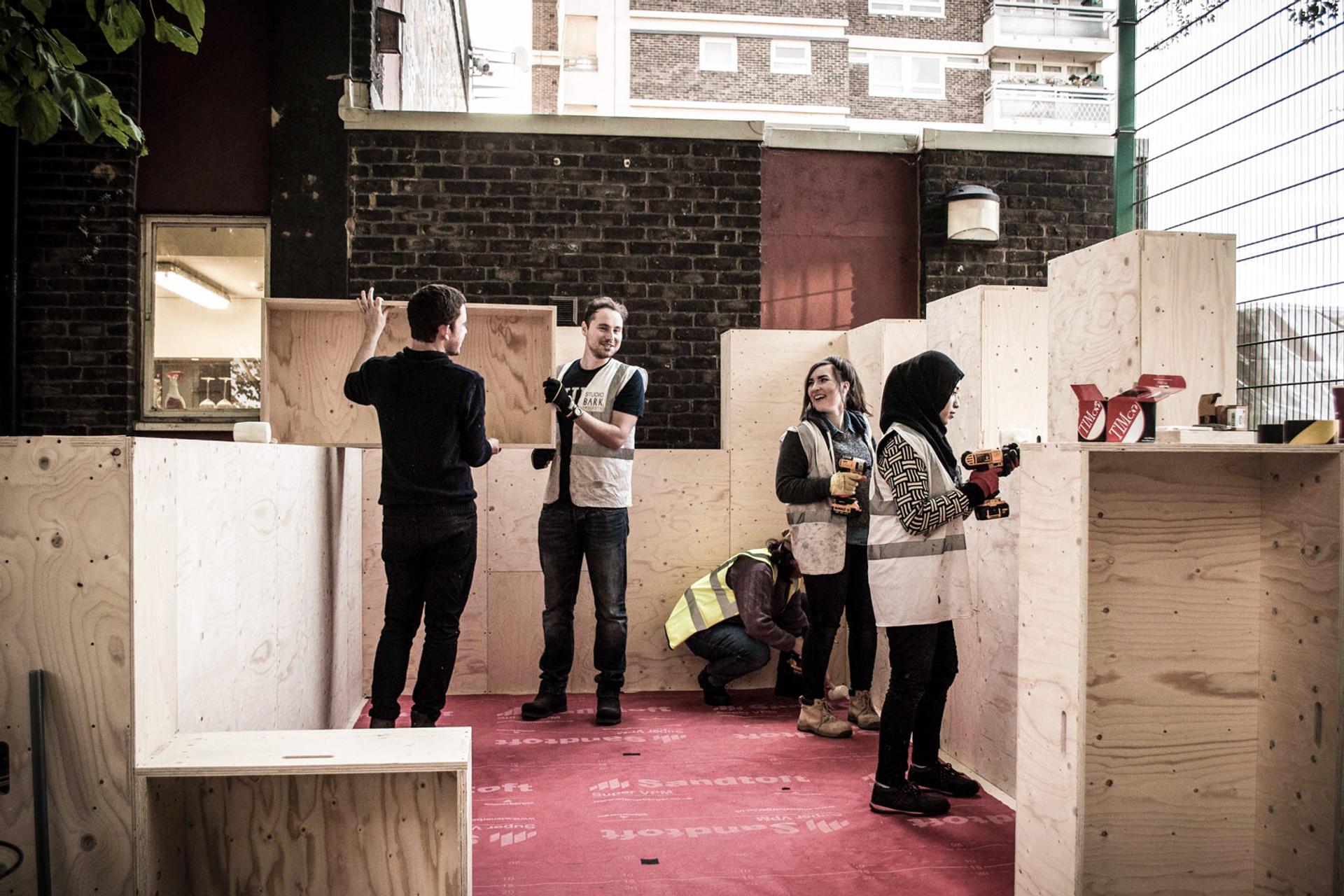A group of people building using modular timber blocks