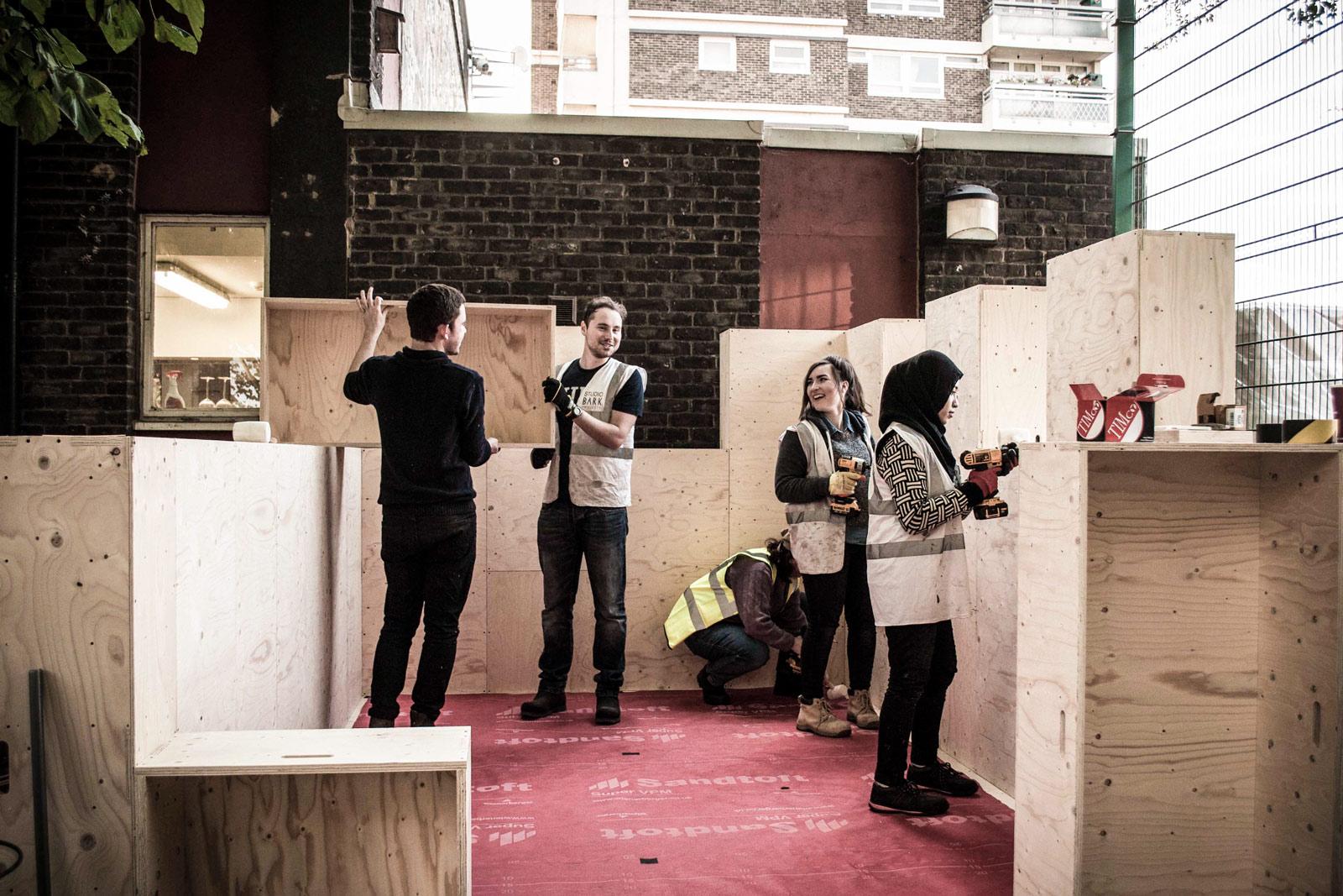A group of people building using modular timber blocks