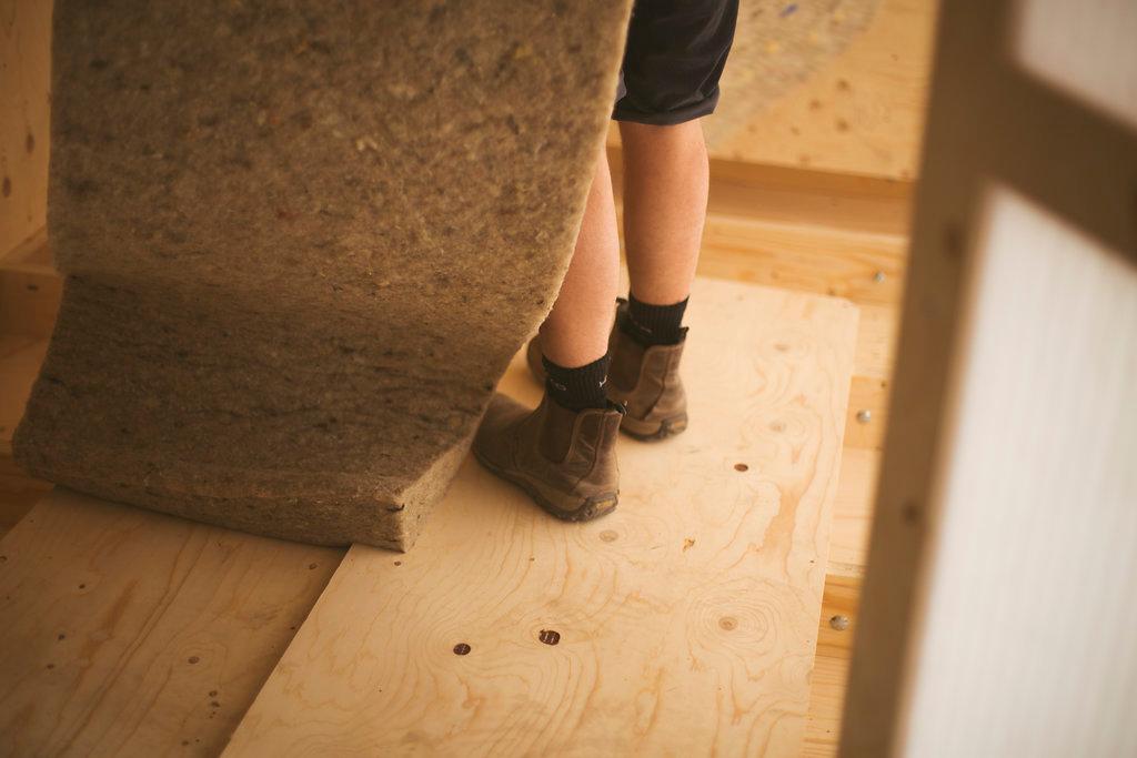 A roll of sheeps wool insulation by a students foot
