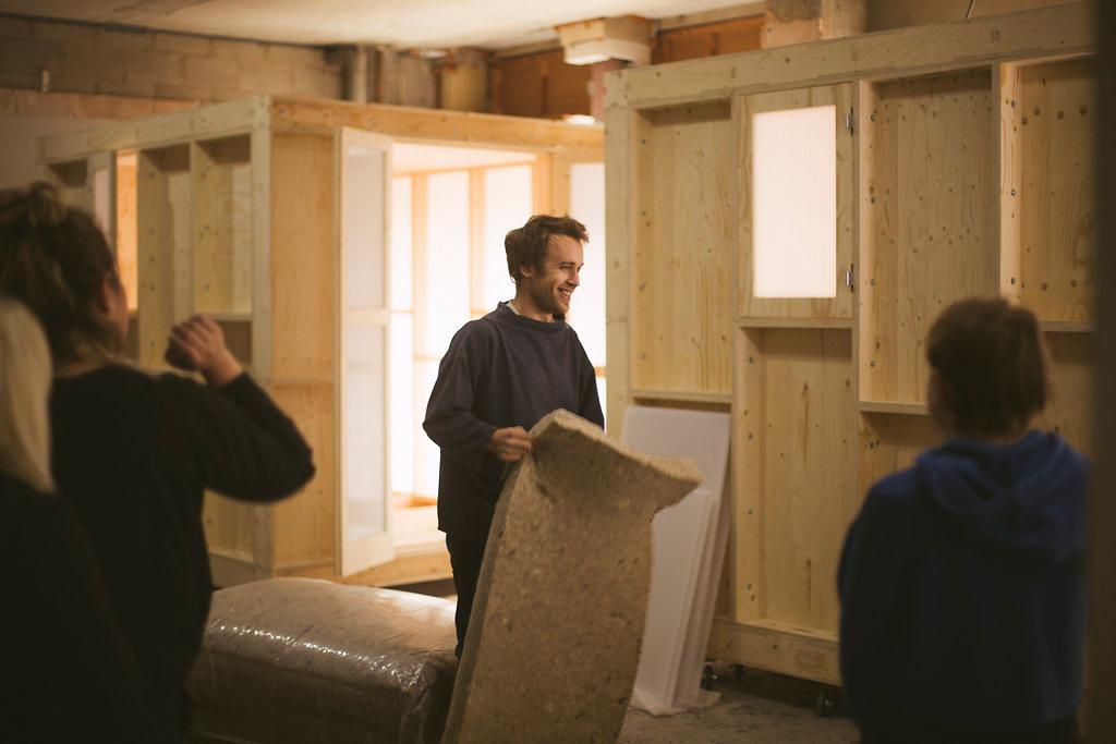 Group of students and studio members around the timber work pod