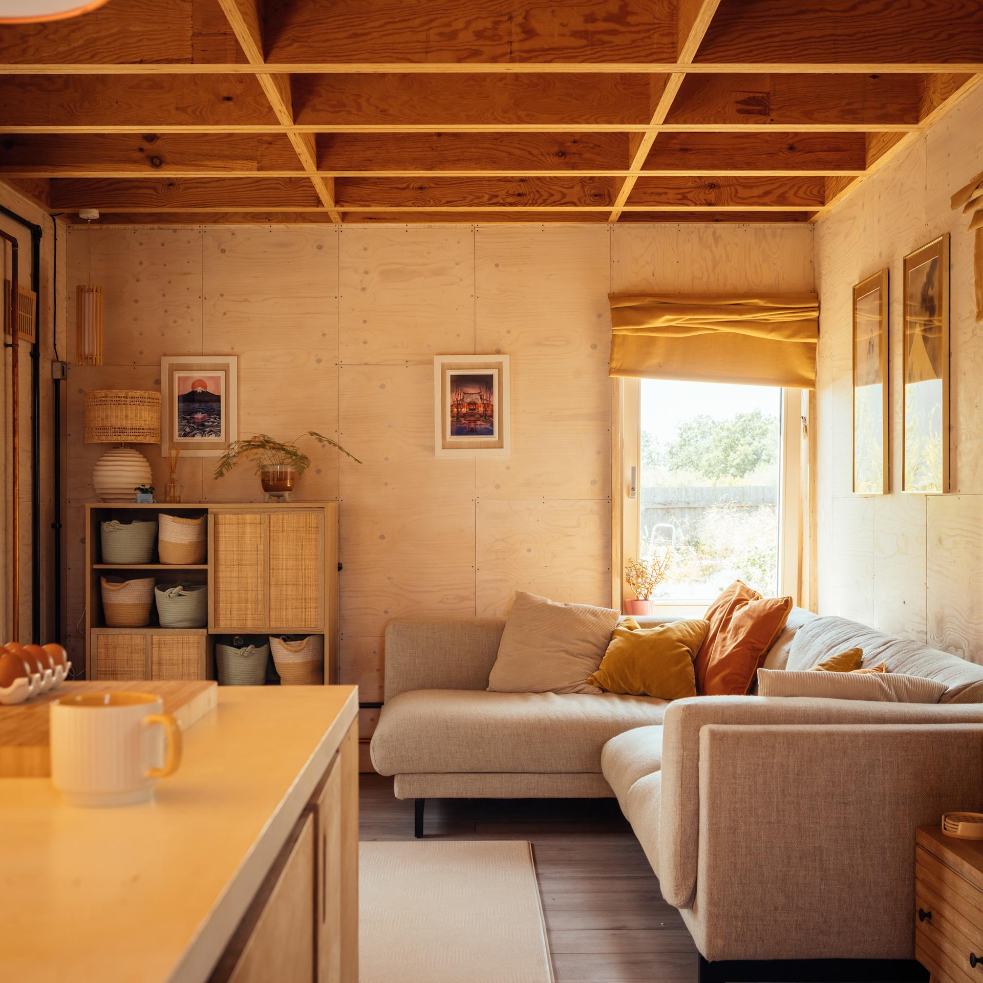 interior view of box house living room with a large grey plush corner sofa