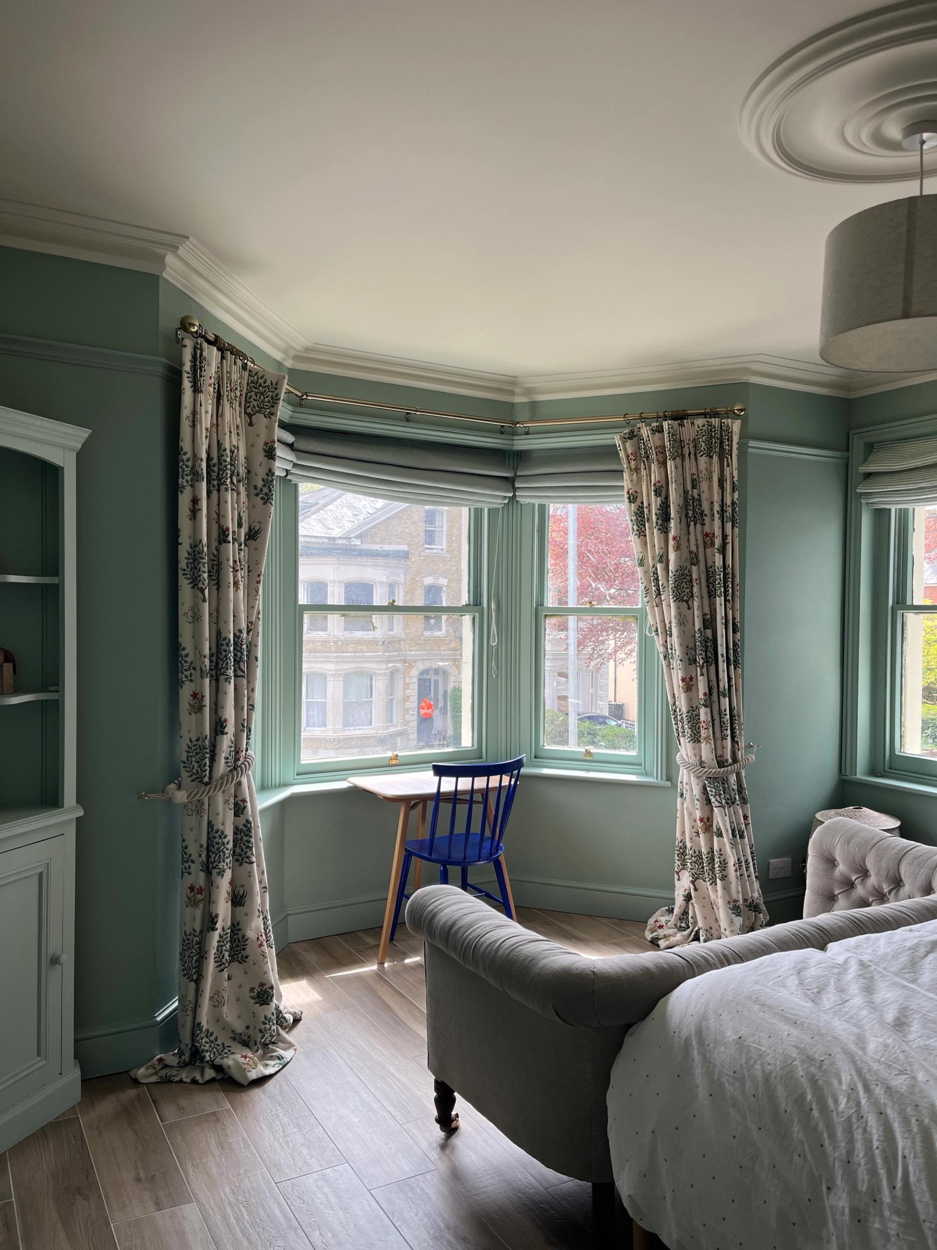 Soft turquoise bedroom with blue chair and late Victorian features