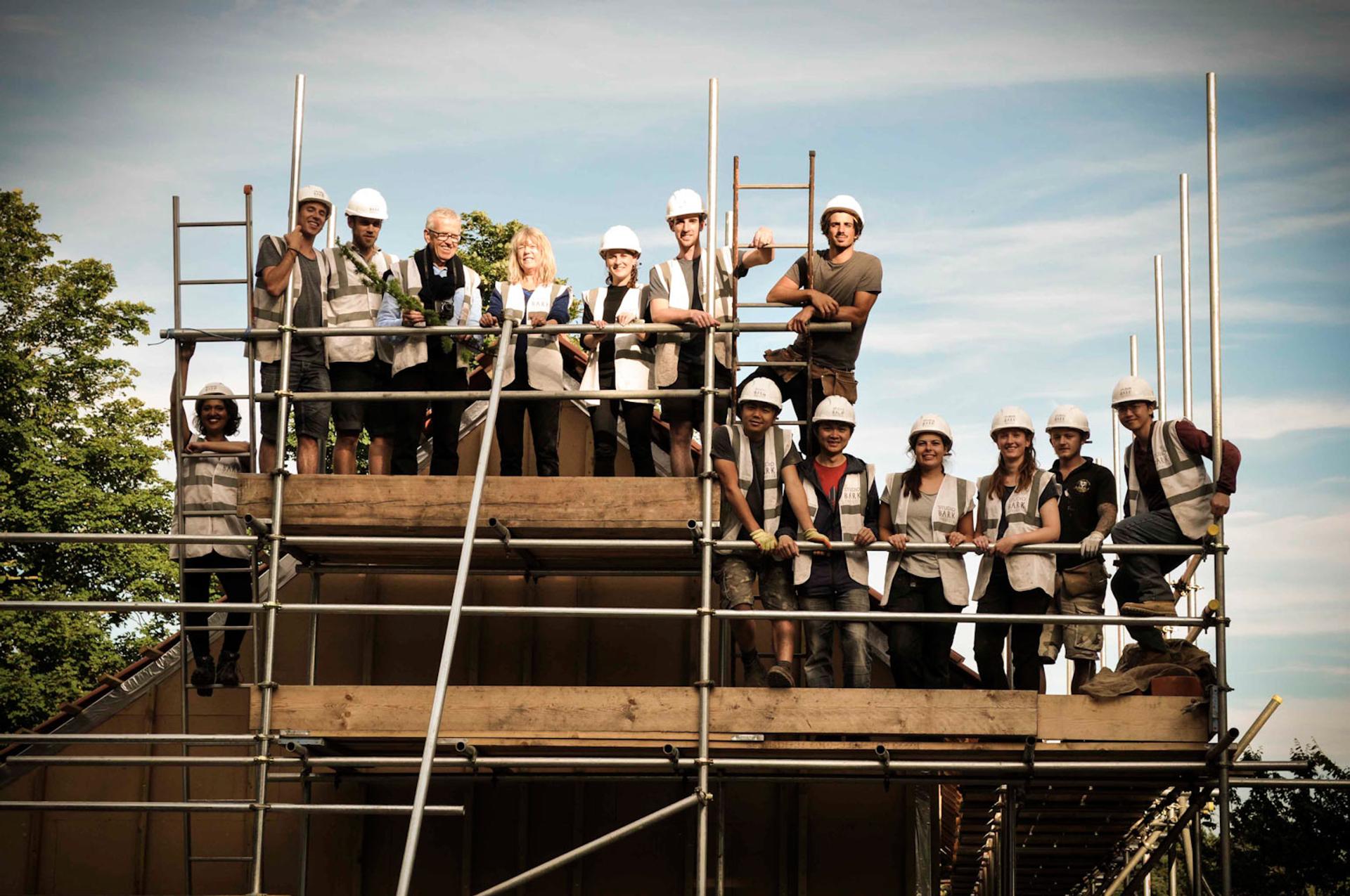 Image of students posing on building scaffolding