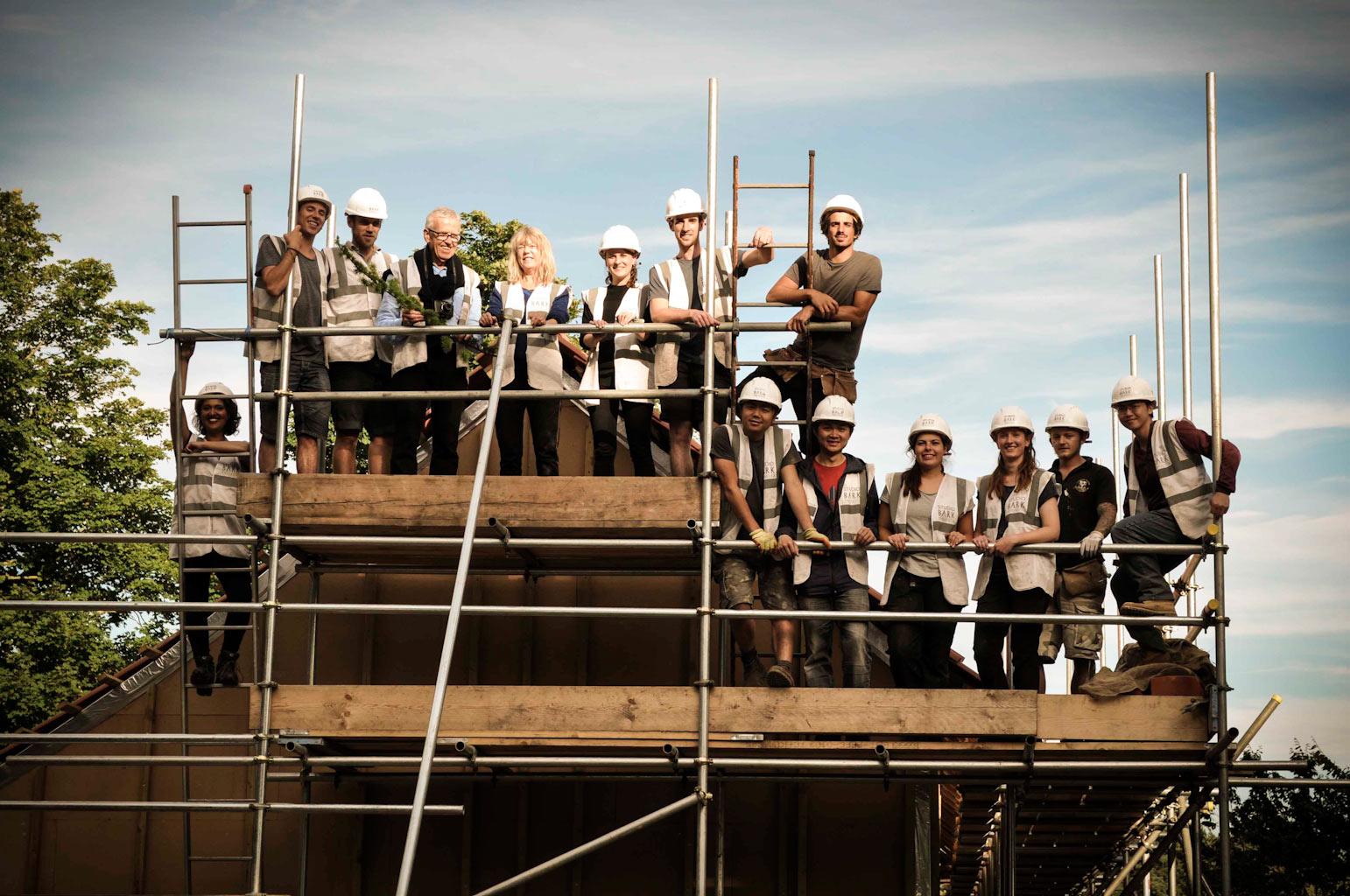 Image of students posing on building scaffolding