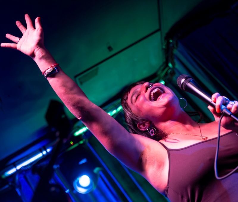 jammer singing, close up shot from below, hand in air and smiling