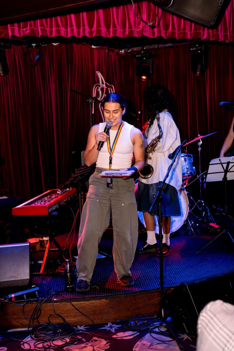 member of the team Hayley Chan on stage with microphone and clipboard, speaking