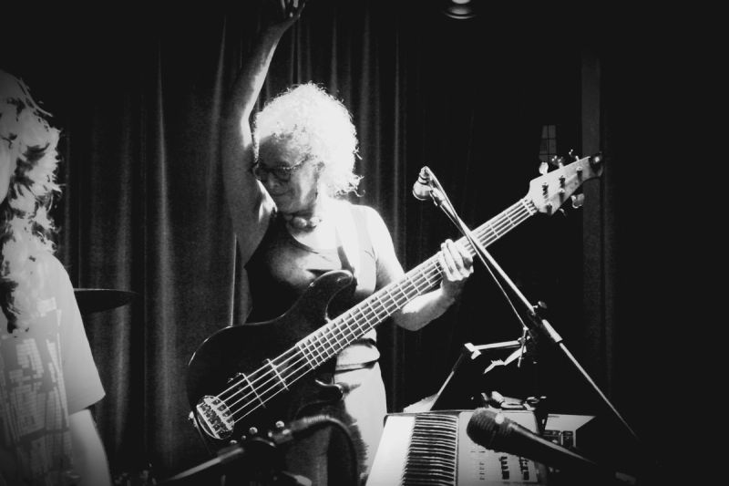 bass player, one arm up dancing with bass in hand