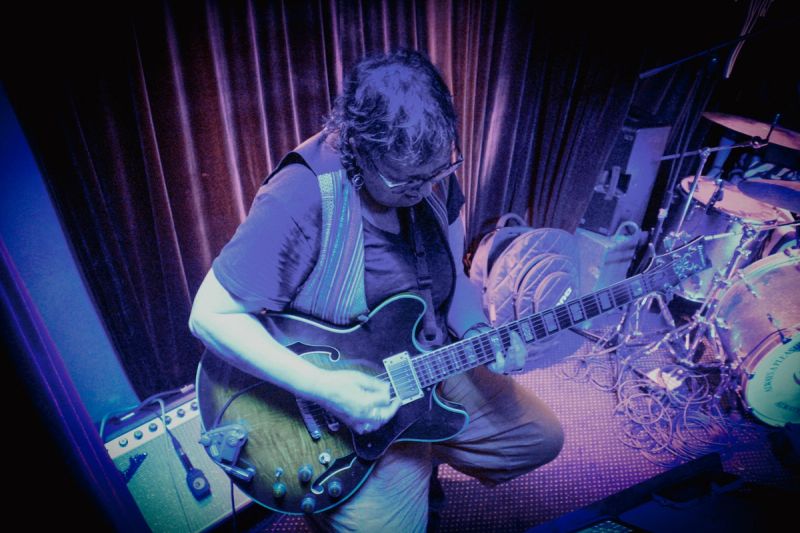 high angle shot on guitar player, looking down playing on stage