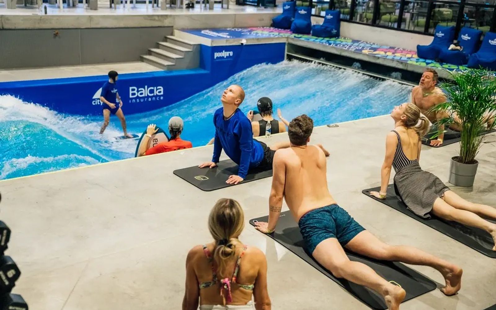 A yoga class on the deck beside the indoor wave at citywave Vilnius.
