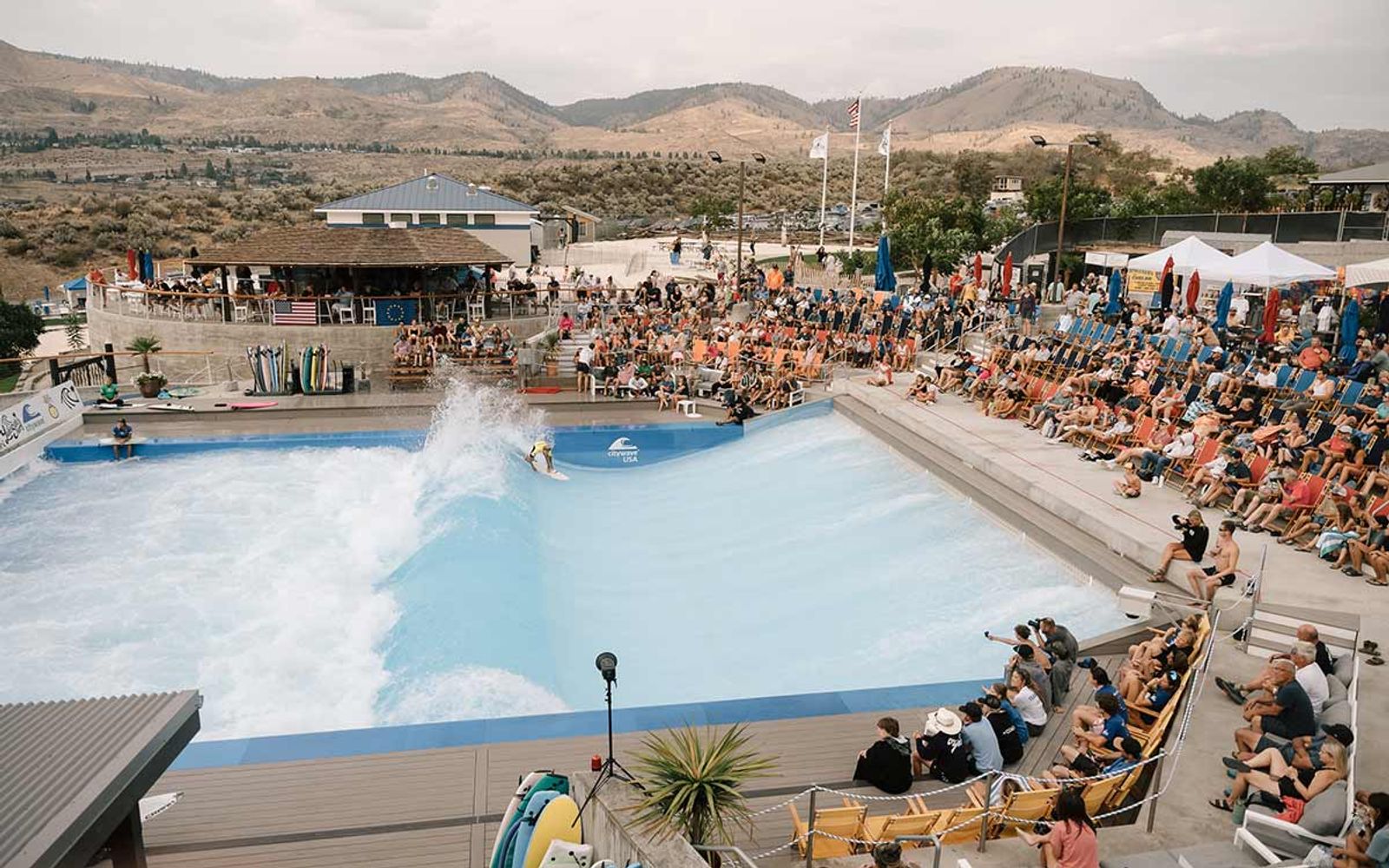 Spectators filling the decks around Lakeside Surf's wave, with the hills around Chelan behind.