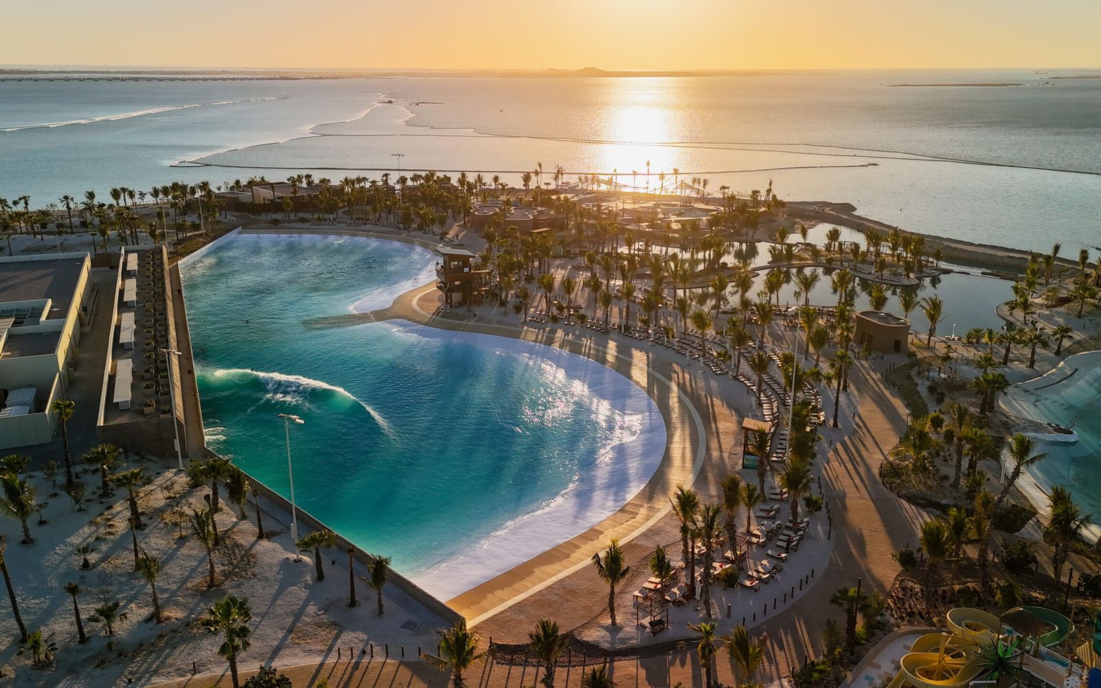 ADRENA's Endless Surf lagoon from above, among palms on the Red Sea coast.