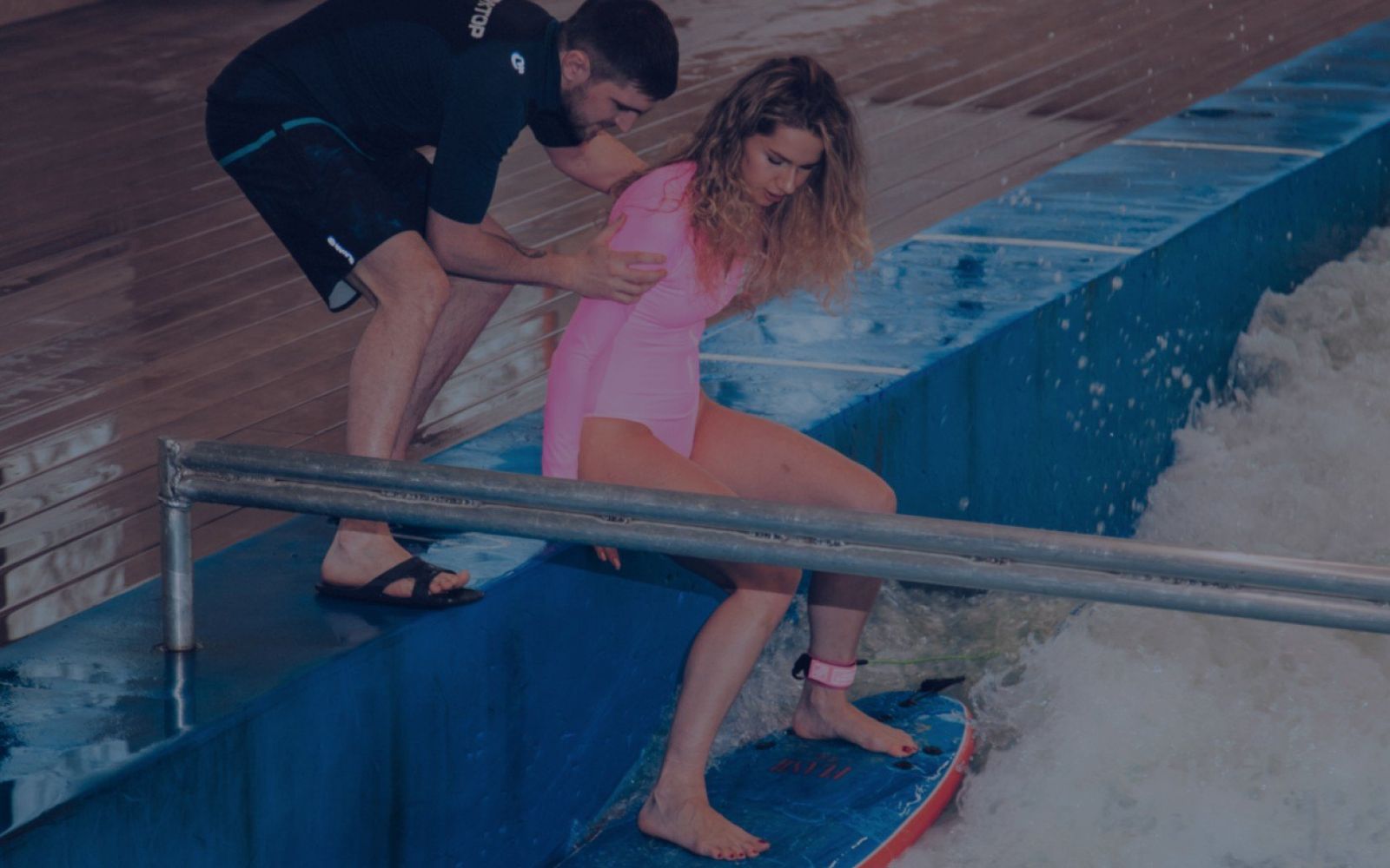 An instructor steadying a beginner on the standing wave at Flow.