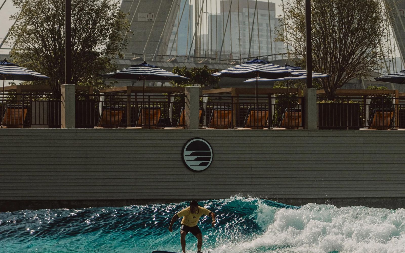 A surfer on São Paulo Surf Club's PerfectSwell pool, below the cables of the Estaiada bridge.