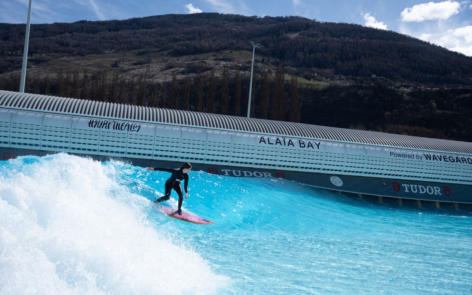 A rider on the Cove wall with the Valais mountains behind. The setting is half the reason to come.