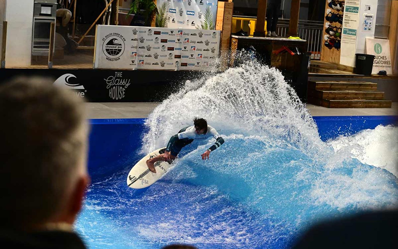 Spectators watch a surfer on The Glassy House's wave from inside the hall.