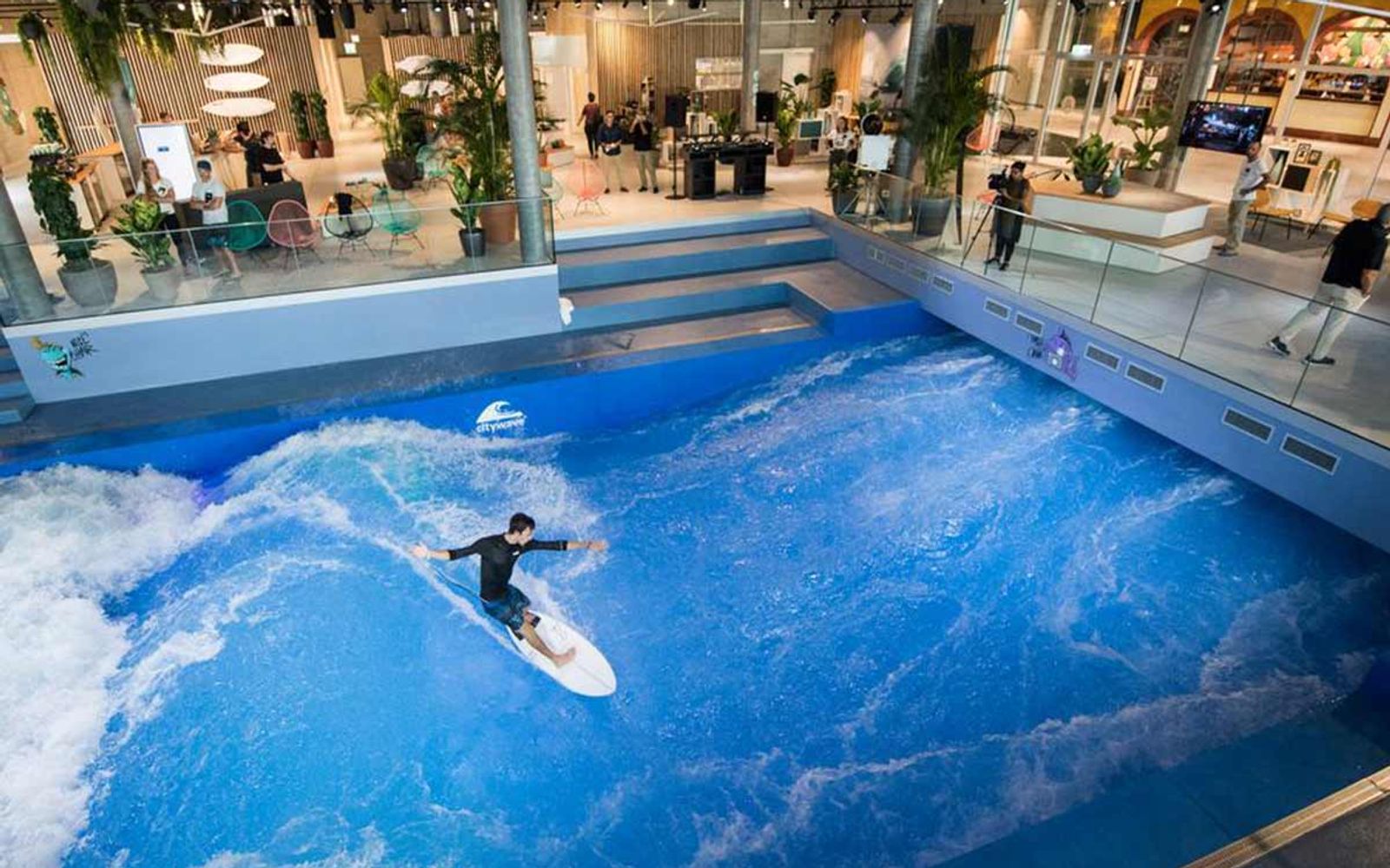A surfer on OANA's indoor wave in Lucerne, seen across the hall.