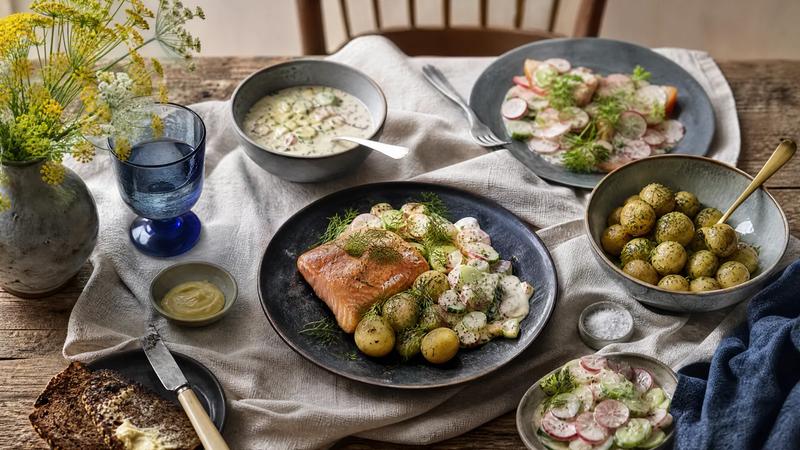 Rustic Nordic wooden table with traditional dishes and a linen cloth, overhead.