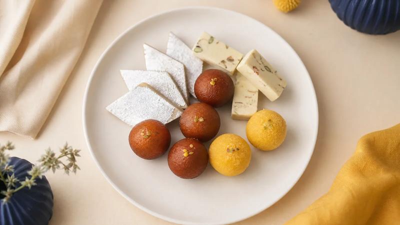 Simple overhead of assorted sweets on a plain white ceramic plate, minimal and clean.