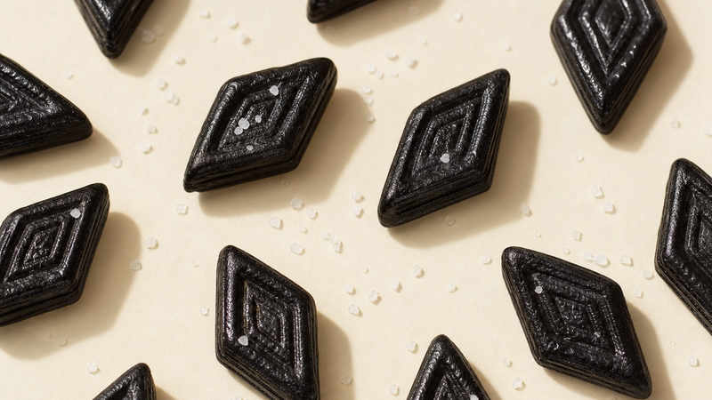Black salty licorice (salmiak) pieces with salt