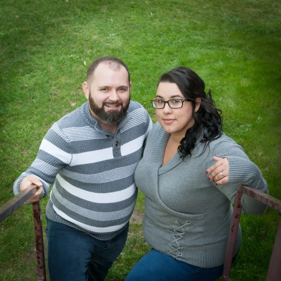 A couple arm in arm on a grassy slope, photographed from above