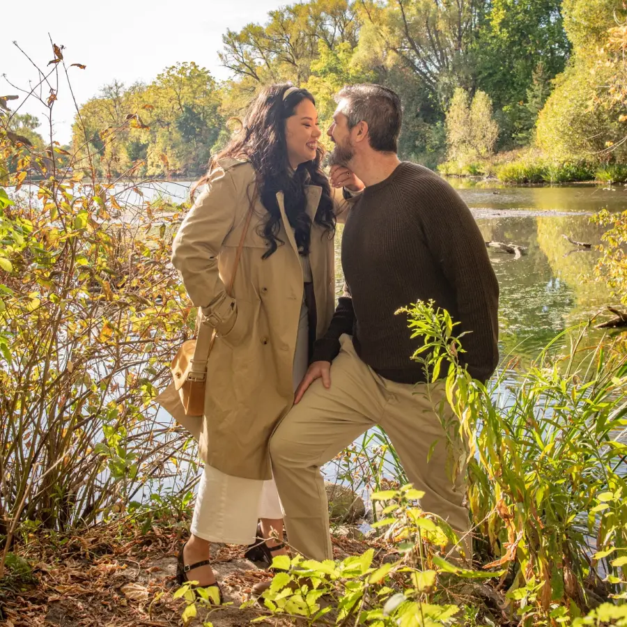 Justine & Josh kissing by a pond in low autumn sun