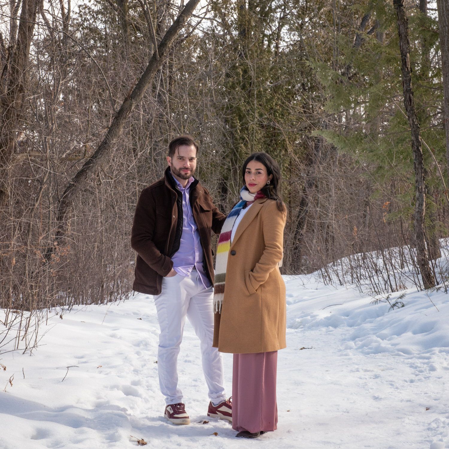 Kisa & Larry standing in the snow, her in a long rose skirt