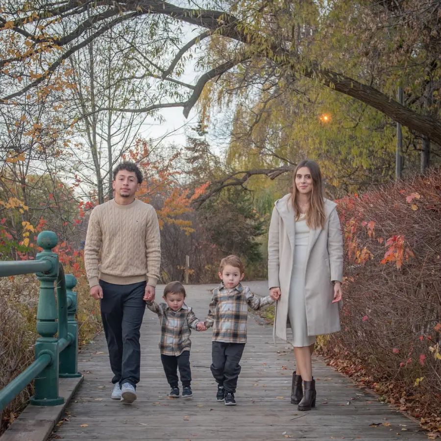 Melanie & Harold and their boys walking a bridge under bare willow branches