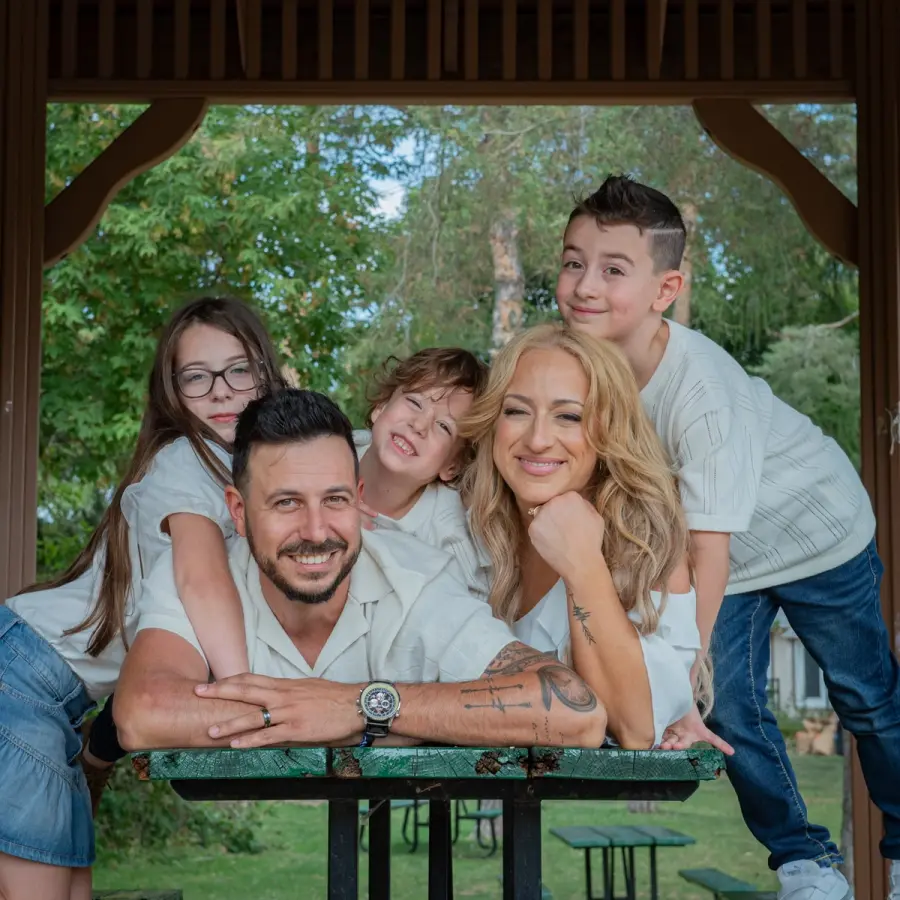 Sara & Rocco leaning on a gazebo table with their four children behind them