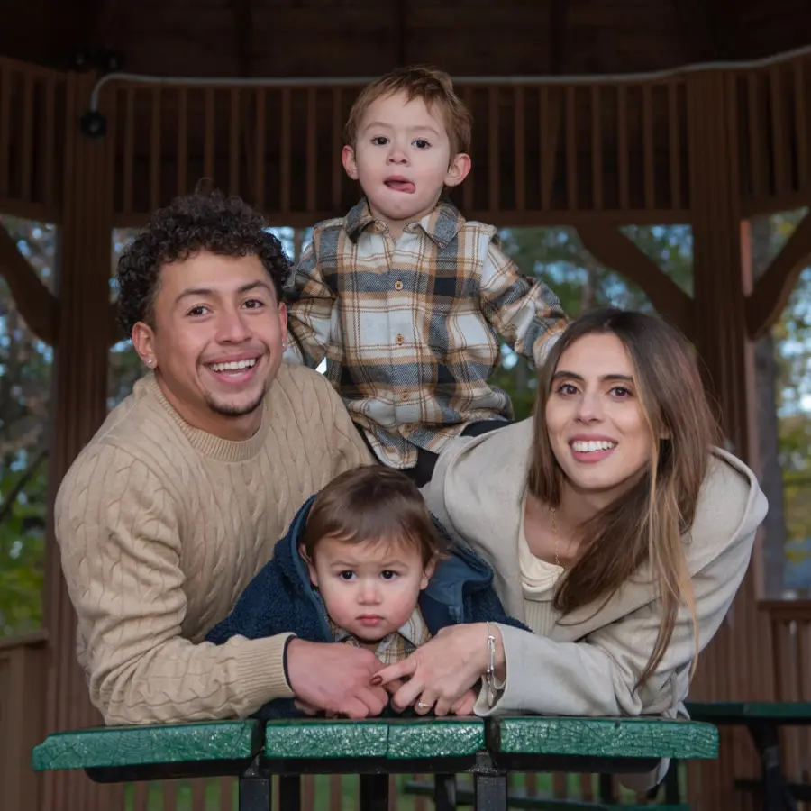 Melanie & Harold leaning on a gazebo table, a toddler on each side