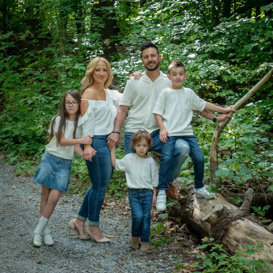 Sara & Rocco's family gathered around a fallen log in the trees