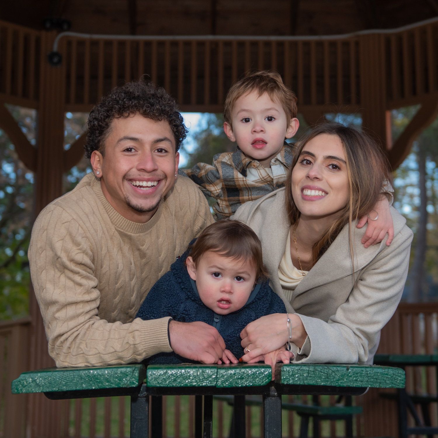 Melanie & Harold with their two little ones leaning over a gazebo table