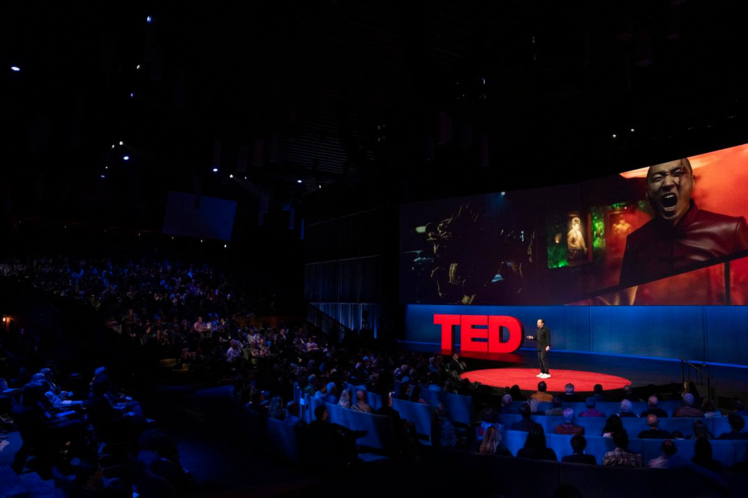 Jason Zada speaks on the stage at TED 2025 to a large audience, engaging them with his presentation.