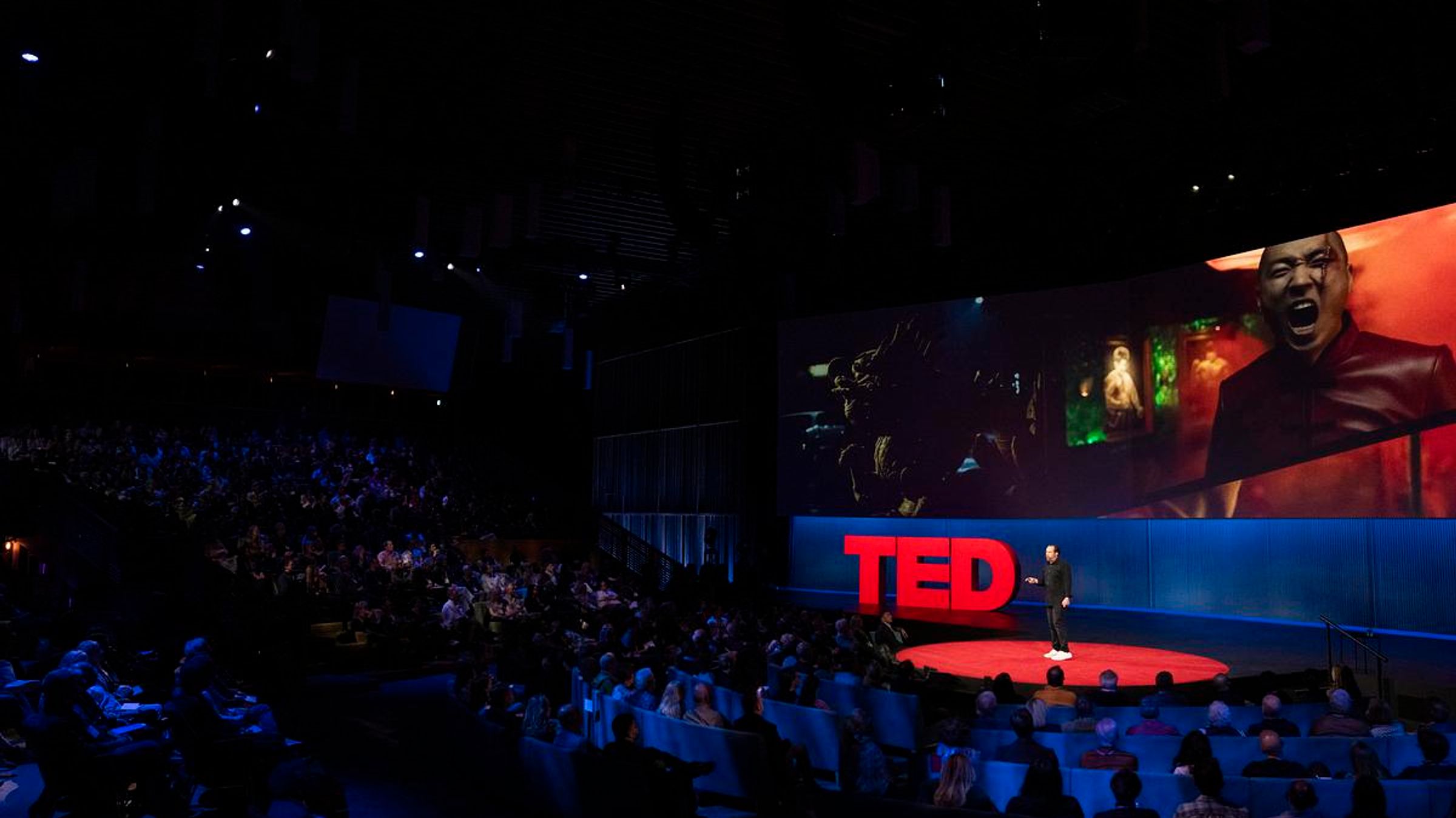 Jason Zada speaks on the stage at TED 2025 to a large audience, engaging them with his presentation.
