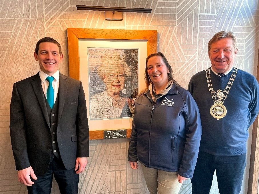 } Neels Ferriera, General Manager of the Skiddaw Hotel; Vanessa Metcalfe, Tourism Manager at Keswick Tourism Association and Alan Dunn, Keswick Mayor photographed with the Queen’s portrait