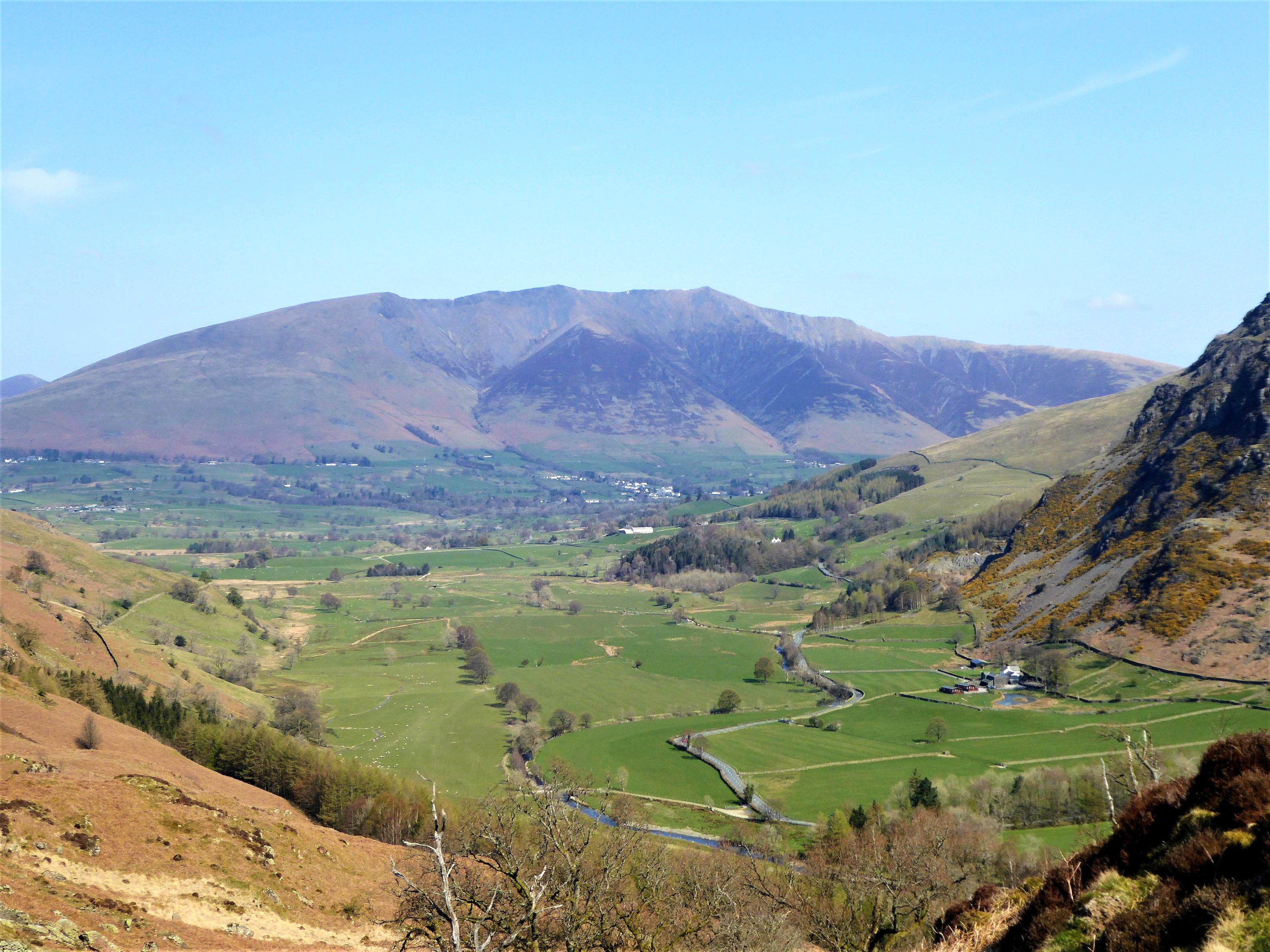The green vale with its farms and walls seen from the ridge with Blencathra beyond