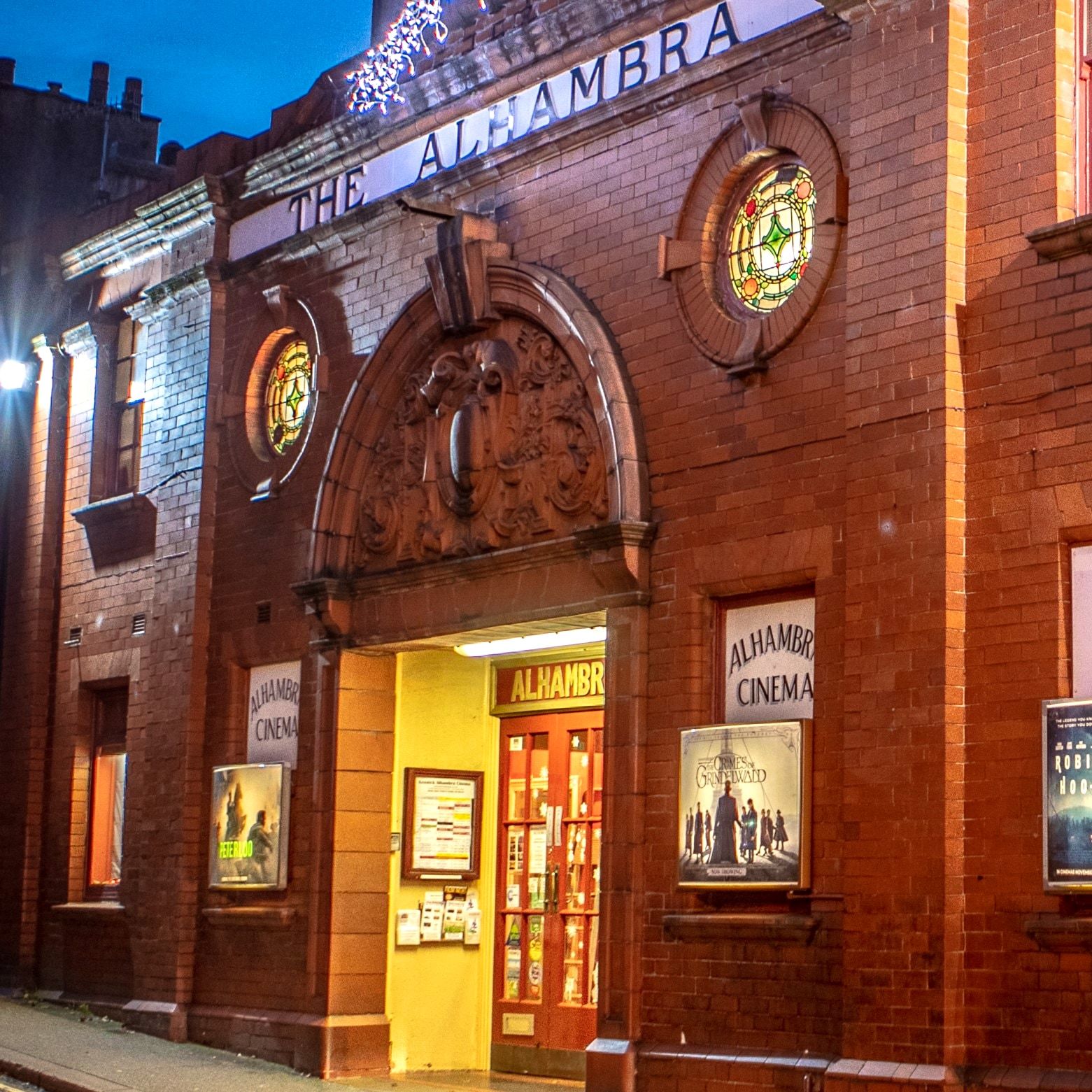 The lit frontage of the Alhambra Cinema in Keswick at dusk