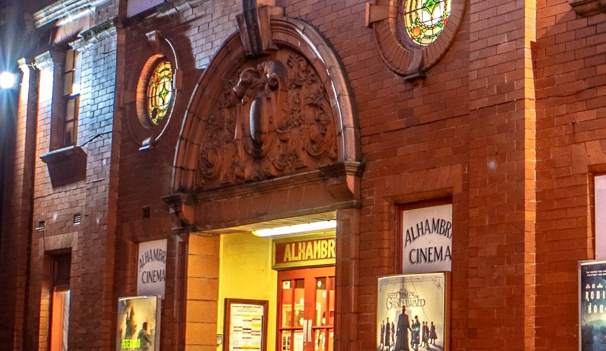 The lit frontage of the Alhambra Cinema in Keswick at dusk