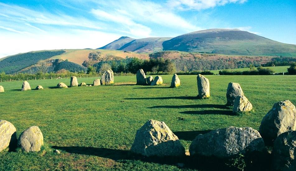 The Castlerigg stone circle on open grass with fells beyond