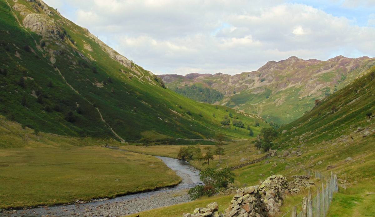 A river winding along the flat floor of Borrowdale between steep green fells