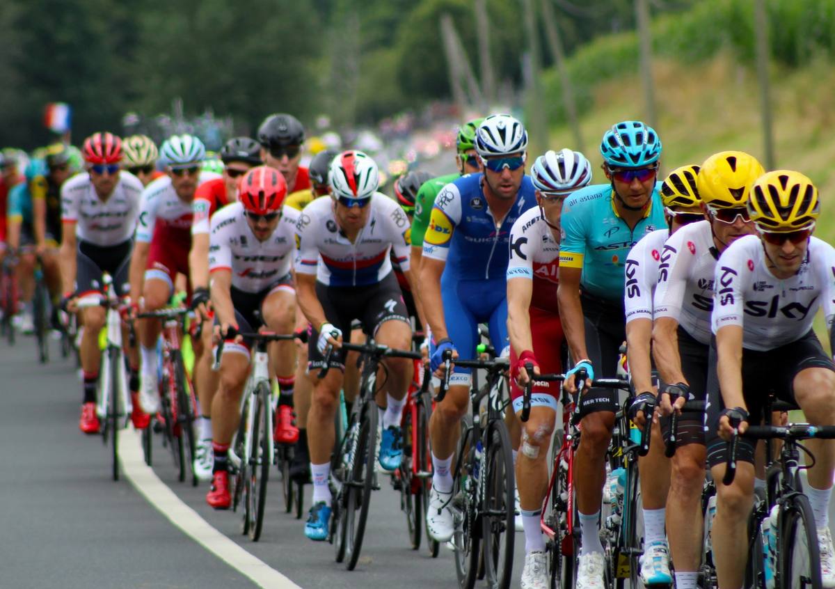 Crowd of cyclists riding through mountains in Tour de France