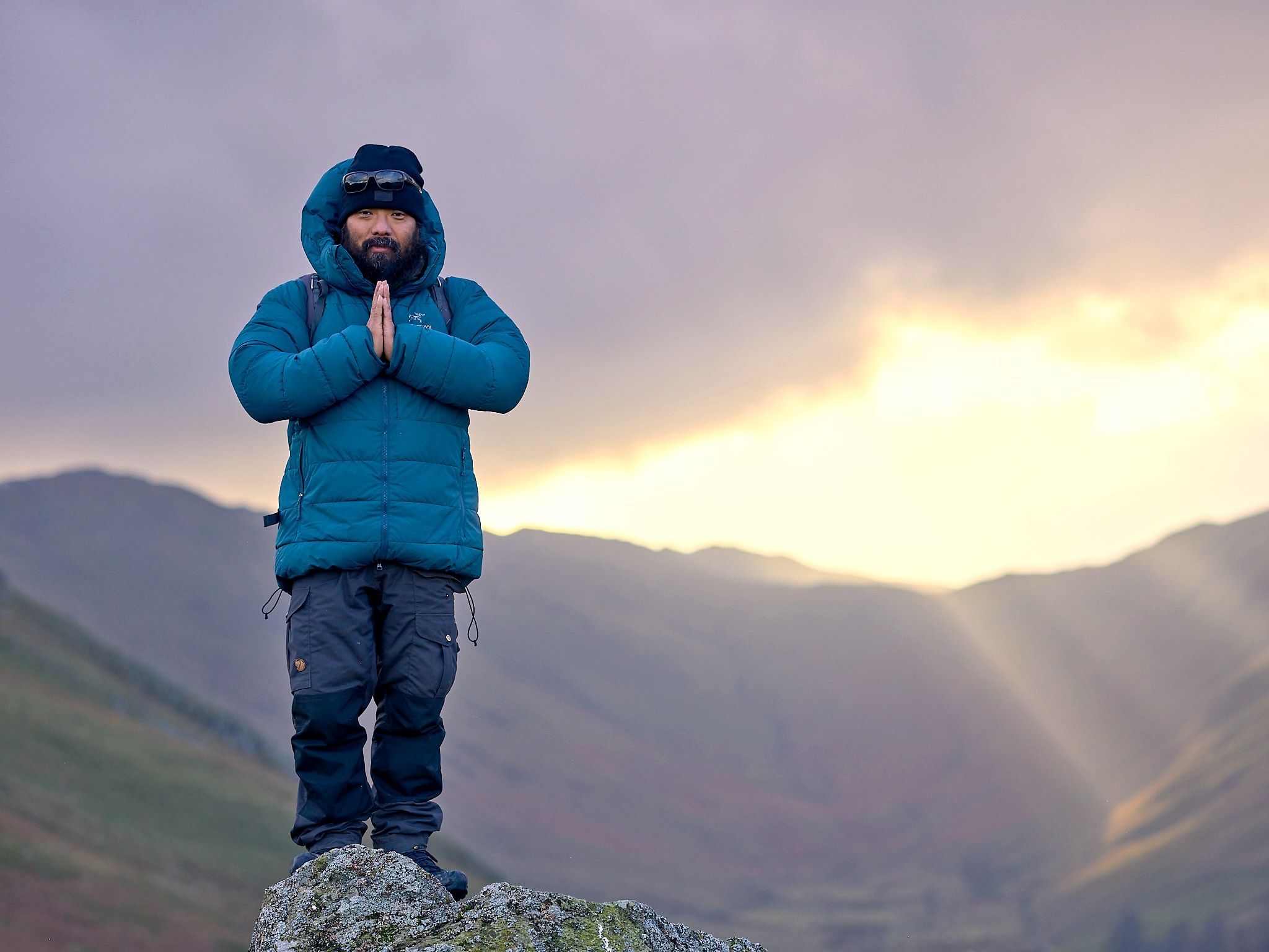 CLimber on top of a mountain in warm clothing