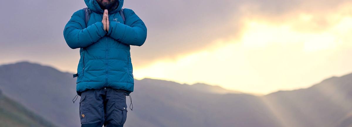 CLimber on top of a mountain in warm clothing