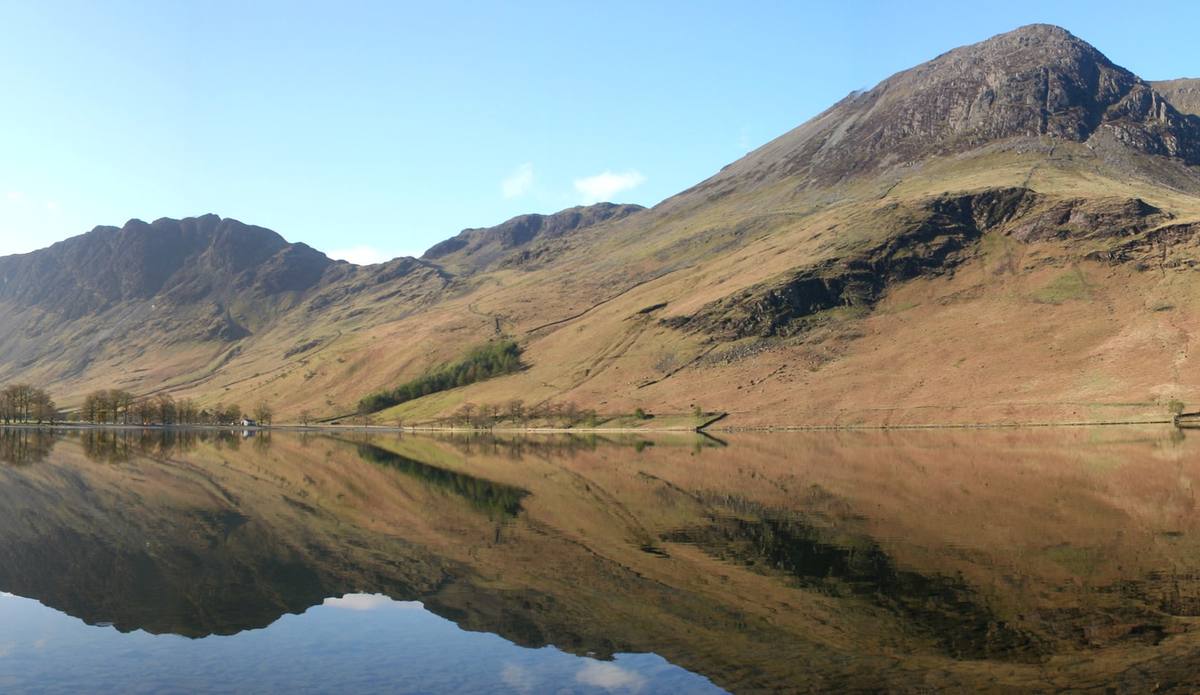 A range of mountains reflected whole in a lake lying completely still